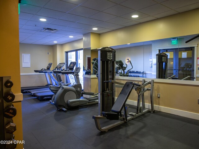 workout area featuring french doors, a drop ceiling, visible vents, and baseboards