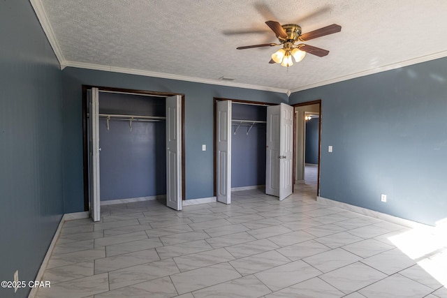 unfurnished bedroom featuring two closets, crown molding, baseboards, and a textured ceiling
