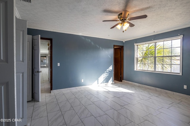 unfurnished room with a textured ceiling, marble finish floor, ornamental molding, and ceiling fan