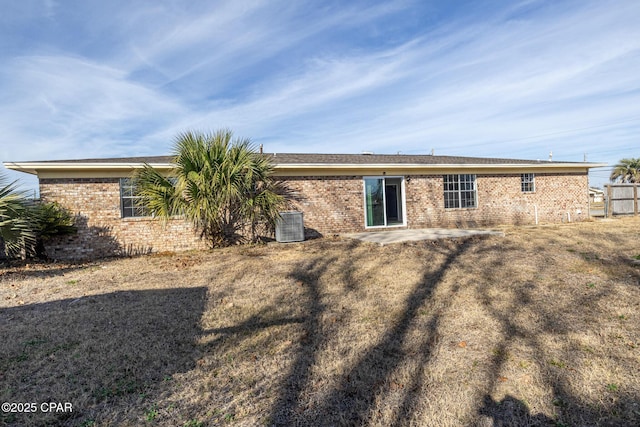 rear view of house featuring a patio, brick siding, and central AC unit