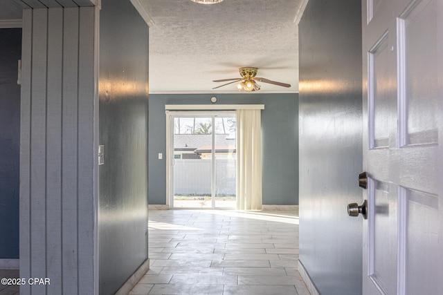 doorway with ceiling fan and a textured ceiling