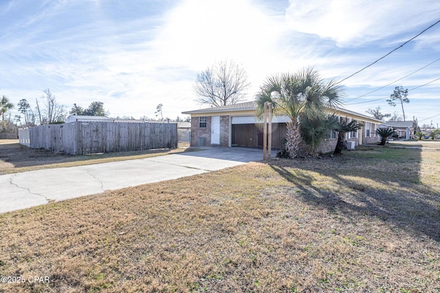 view of front of property featuring concrete driveway, a front yard, and fence