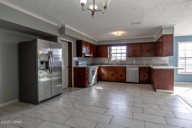 kitchen featuring light countertops, appliances with stainless steel finishes, plenty of natural light, and a chandelier