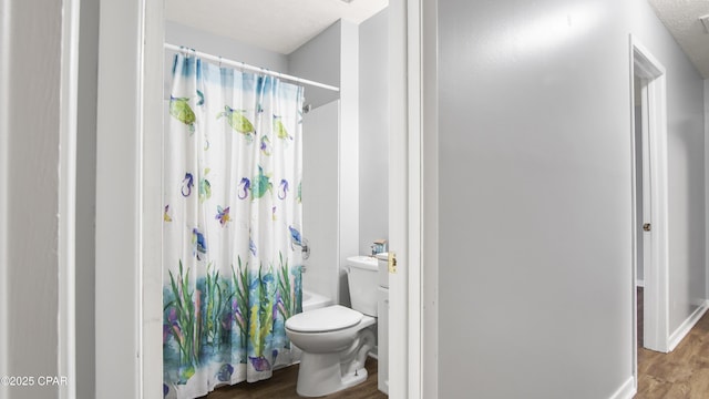 bathroom with toilet, wood-type flooring, and shower / bathtub combination with curtain