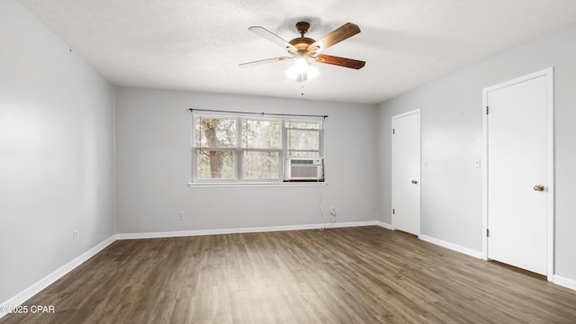 unfurnished bedroom with cooling unit, ceiling fan, dark hardwood / wood-style flooring, and a textured ceiling