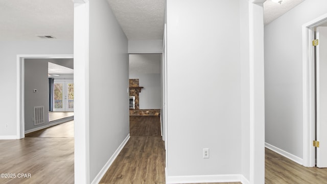 hallway featuring hardwood / wood-style floors and a textured ceiling