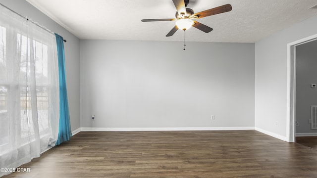 spare room featuring ceiling fan, dark wood-type flooring, and a textured ceiling