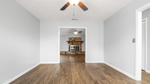 unfurnished dining area with ceiling fan, dark hardwood / wood-style floors, and a textured ceiling