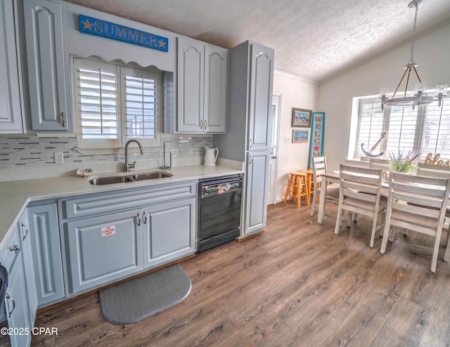 kitchen with pendant lighting, sink, dishwasher, plenty of natural light, and dark hardwood / wood-style floors