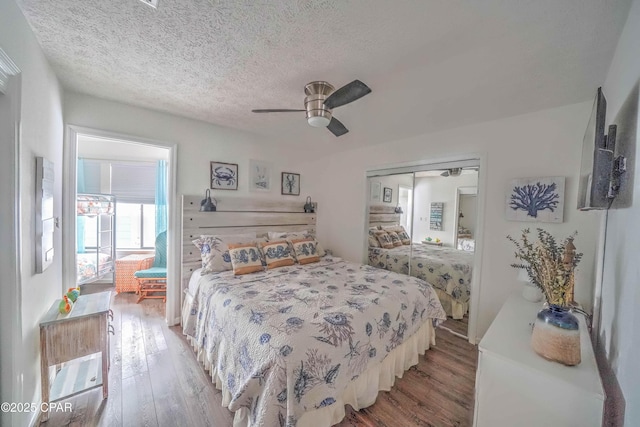 bedroom featuring wood-type flooring, ceiling fan, a textured ceiling, and a closet