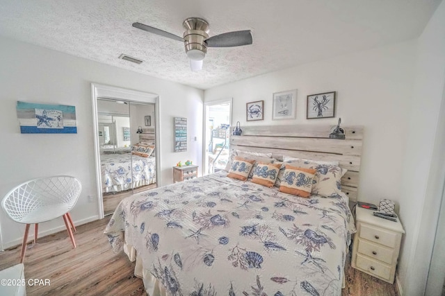 bedroom with ceiling fan, a closet, a textured ceiling, and light hardwood / wood-style flooring