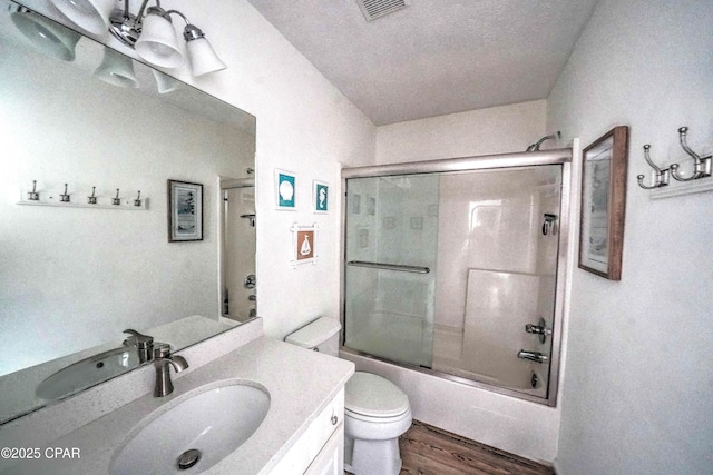 full bathroom featuring vanity, combined bath / shower with glass door, wood-type flooring, and toilet