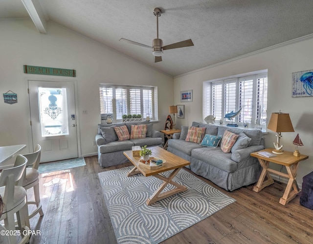 living room with a healthy amount of sunlight, wood-type flooring, and lofted ceiling with beams