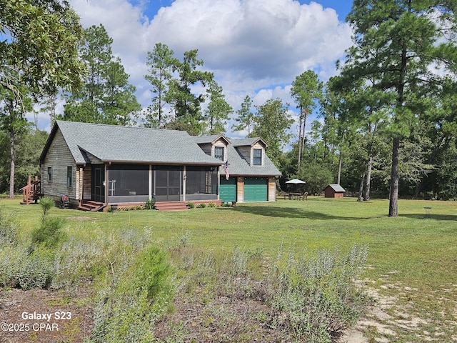 view of front of property with a front lawn, a garage, and a sunroom