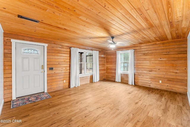 interior space with wood walls, light hardwood / wood-style flooring, and wooden ceiling