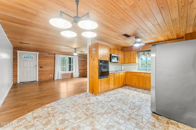 kitchen featuring wood ceiling, black appliances, ceiling fan, light hardwood / wood-style floors, and backsplash