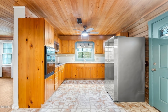 kitchen with sink, ceiling fan, black appliances, decorative backsplash, and wooden ceiling