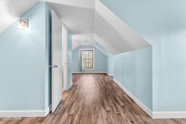 bonus room with vaulted ceiling and light hardwood / wood-style floors