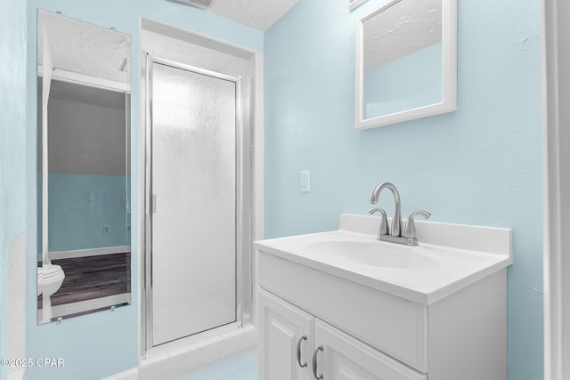 bathroom with vanity, toilet, and a shower with shower door