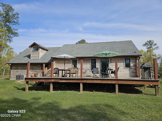 rear view of property with central AC unit, a deck, and a lawn