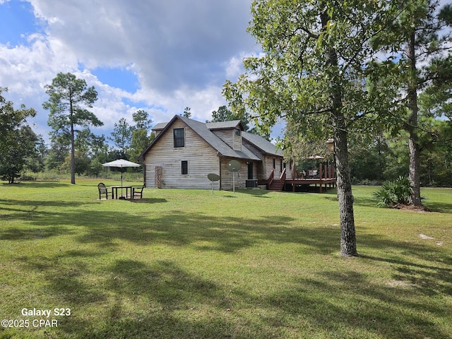 view of side of home with a wooden deck, central AC unit, and a lawn