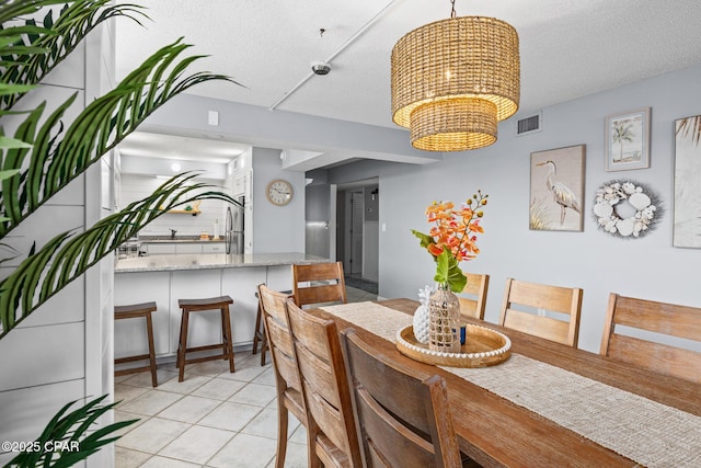 5801 Thomas Dr Unit 601, Panama City Beach, FL 32408 - dining space featuring visible vents, an inviting chandelier, a textured ceiling, and light tile patterned flooring