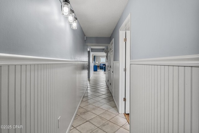 5801 Thomas Dr Unit 601, Panama City Beach, FL 32408 - hall featuring a wainscoted wall and light tile patterned floors