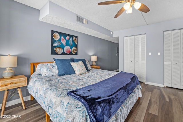 5801 Thomas Dr Unit 601, Panama City Beach, FL 32408 - bedroom featuring two closets, baseboards, wood finished floors, and a textured ceiling