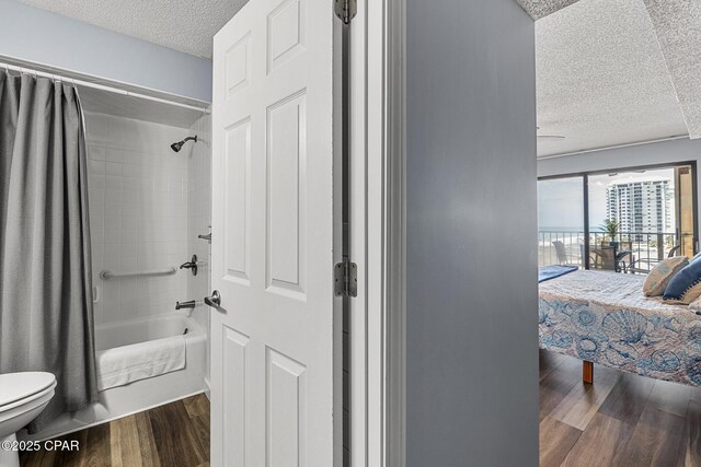 5801 Thomas Dr Unit 601, Panama City Beach, FL 32408 - ensuite bathroom with a textured ceiling, toilet, shower / tub combo with curtain, wood finished floors, and connected bathroom