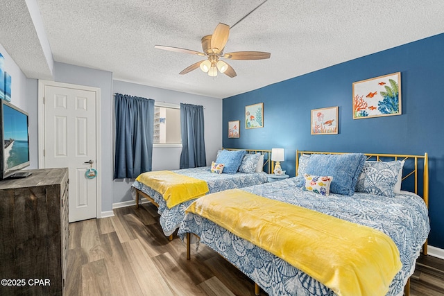 5801 Thomas Dr Unit 601, Panama City Beach, FL 32408 - bedroom with ceiling fan, baseboards, wood finished floors, and a textured ceiling