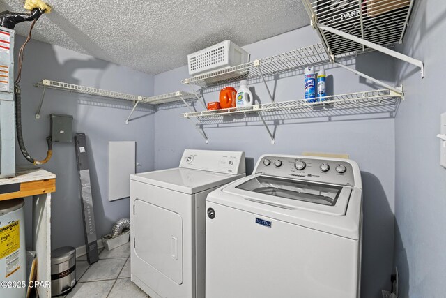 5801 Thomas Dr Unit 601, Panama City Beach, FL 32408 - laundry room with water heater, laundry area, light tile patterned floors, washing machine and clothes dryer, and a textured ceiling