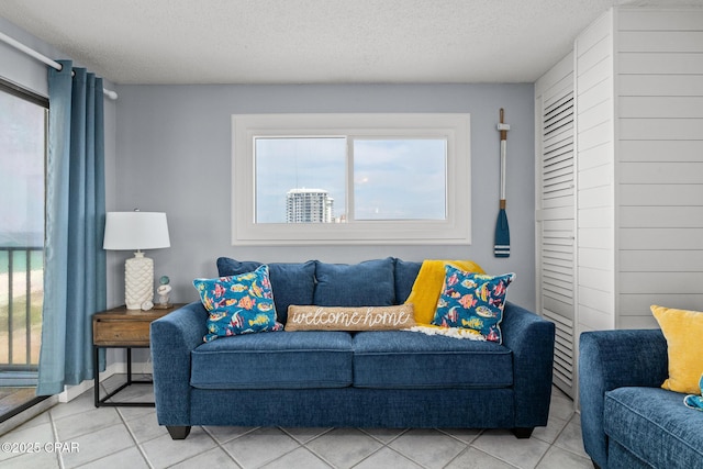 5801 Thomas Dr Unit 601, Panama City Beach, FL 32408 - tiled living room with baseboards, a textured ceiling, and a healthy amount of sunlight