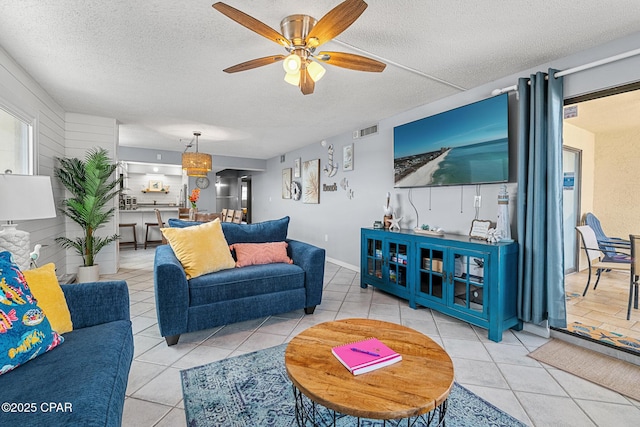 5801 Thomas Dr Unit 601, Panama City Beach, FL 32408 - living room featuring a textured ceiling, visible vents, a ceiling fan, and light tile patterned floors