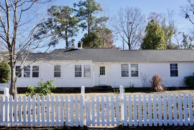 view of front facade with entry steps, a fenced front yard, a chimney, and a shingled roof