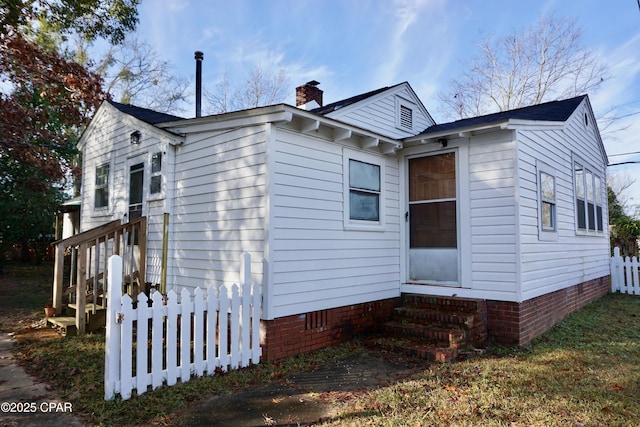 exterior space featuring entry steps, fence, and a chimney