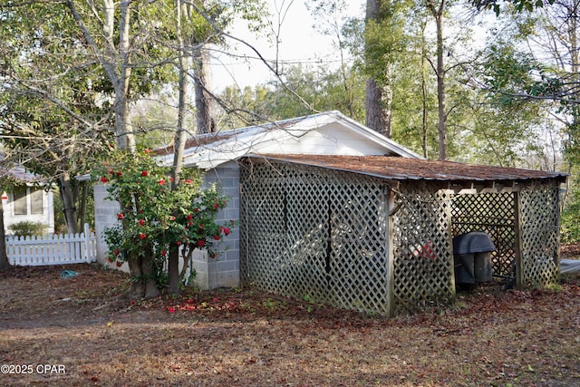 view of property exterior with concrete block siding and fence