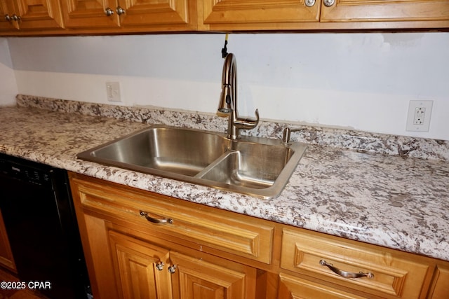 kitchen featuring brown cabinetry, a sink, light stone counters, and dishwasher