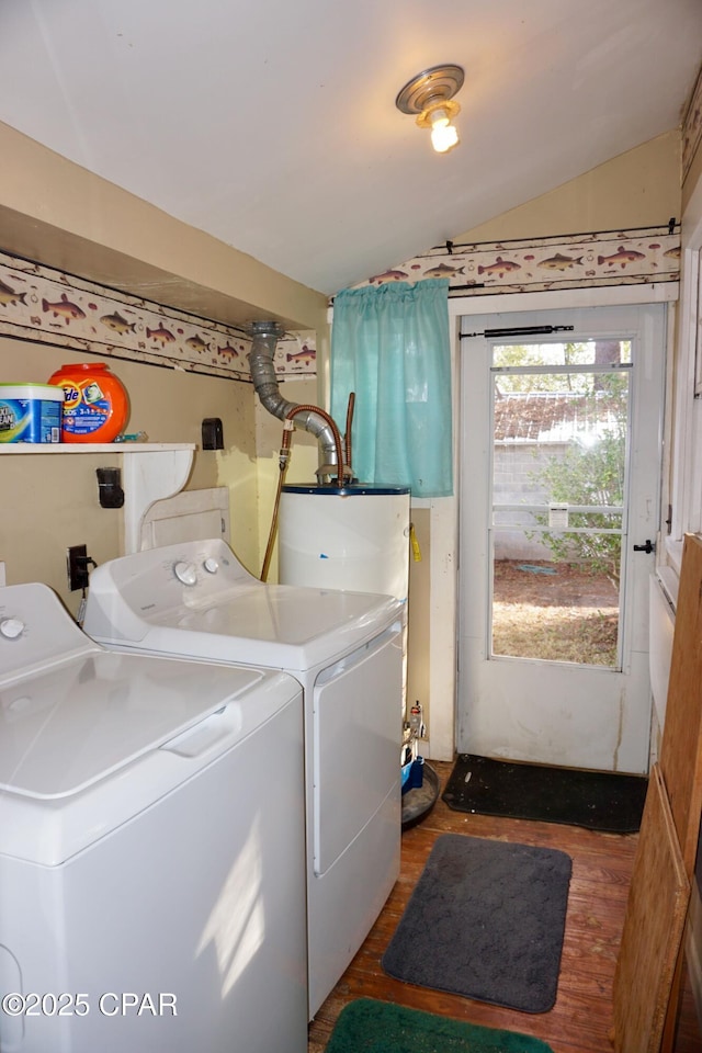 clothes washing area featuring water heater, laundry area, wood finished floors, and washing machine and clothes dryer