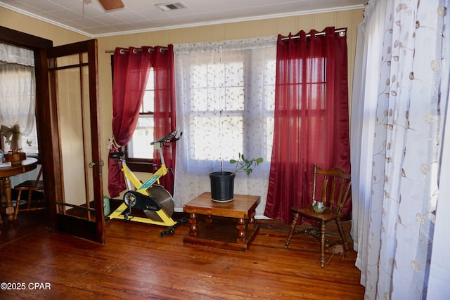 sitting room featuring wood-type flooring, visible vents, and crown molding