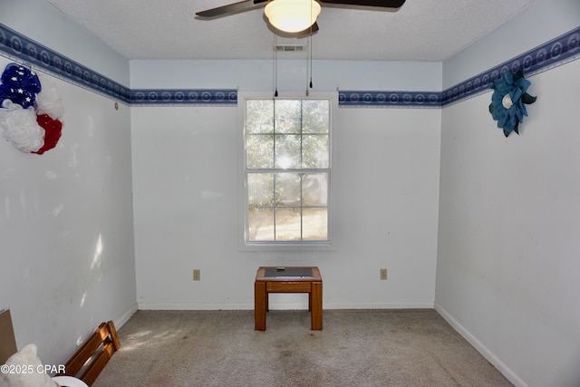 unfurnished dining area with a textured ceiling, carpet flooring, and baseboards