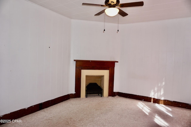 unfurnished living room featuring a ceiling fan, carpet flooring, and a fireplace