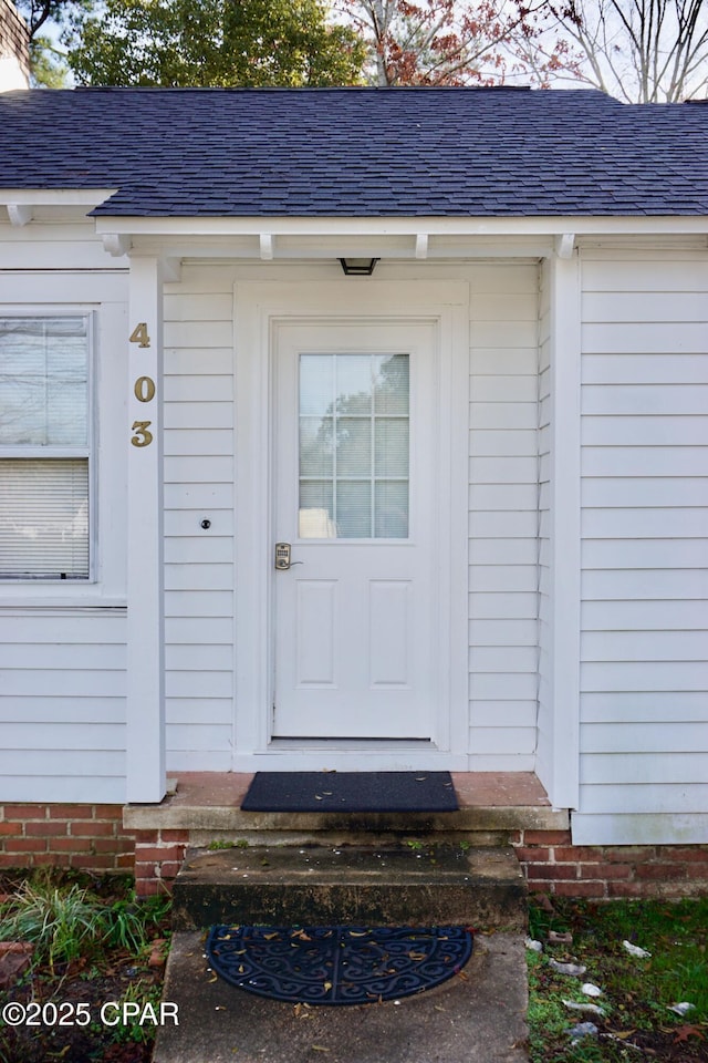 entrance to property with roof with shingles