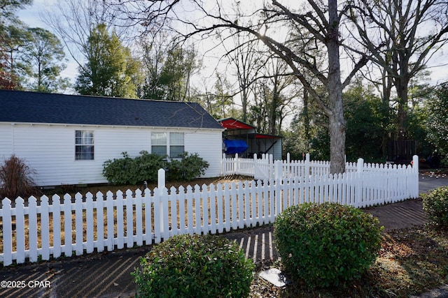 view of front facade with roof with shingles and a fenced front yard