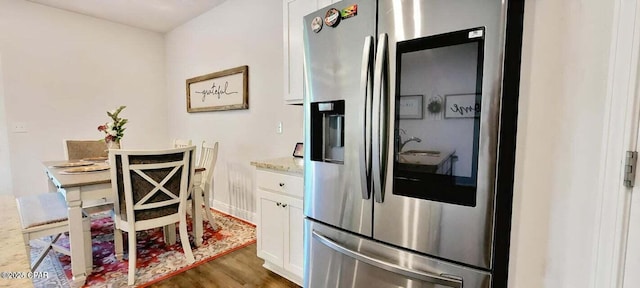 kitchen featuring dark hardwood / wood-style floors, white cabinets, and stainless steel refrigerator with ice dispenser