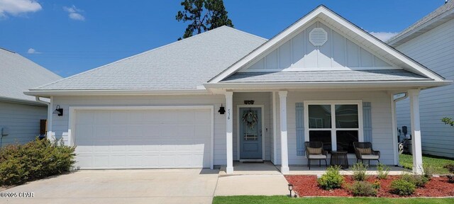 view of front of home with a porch, a garage, and a front lawn