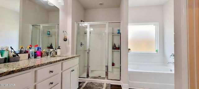 bathroom with vanity and shower with separate bathtub