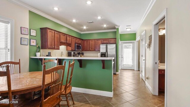 kitchen with stainless steel appliances, light countertops, and crown molding