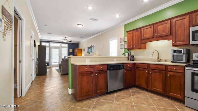 kitchen with a peninsula, plenty of natural light, appliances with stainless steel finishes, and ornamental molding