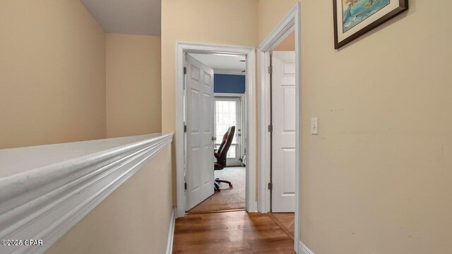 hallway with baseboards and wood finished floors