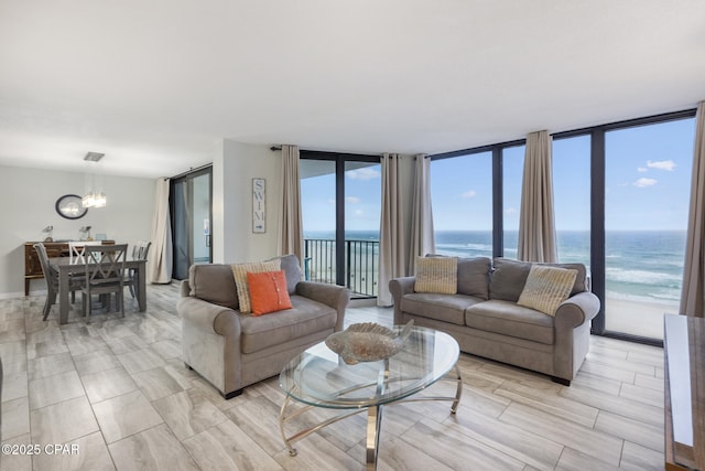 living area featuring a water view, a notable chandelier, and floor to ceiling windows